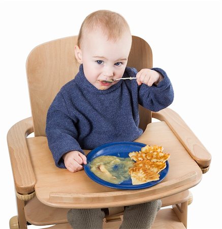 young child eating in high chair isolated in white backgound Foto de stock - Royalty-Free Super Valor e Assinatura, Número: 400-06175646