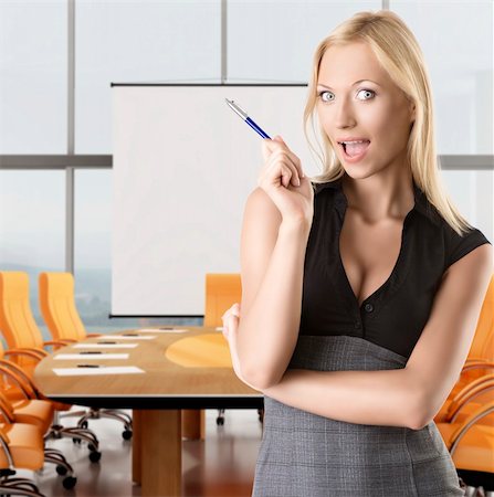 secretary model - pretty business woman with elegant dress and pen, she is in font the camera, takes pen with right hand and looks in to the lens with open mouth Stock Photo - Budget Royalty-Free & Subscription, Code: 400-06176960