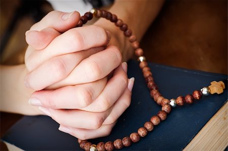 reverence - female hands with rosary and blue bible book  praying  on wooden table surface Stock Photo - Budget Royalty-Free & Subscription, Code: 400-06177009