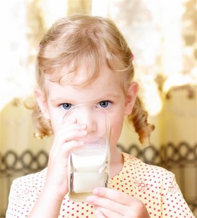 small beautiful girl drinks milk from a glass Photographie de stock - Aubaine LD & Abonnement, Code: 400-06177128