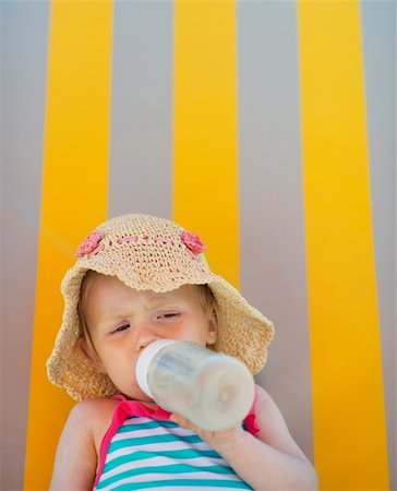 Baby laying on sun bed and drinking from bottle Stock Photo - Budget Royalty-Free & Subscription, Code: 400-06177555