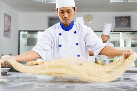 Chef making noodle in the kitchen of cooking school. ***PS : selective focus on the noodle with noticable movement blur *** Photographie de stock - Aubaine LD & Abonnement, Code: 400-06178019