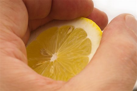 simsearch:400-08814206,k - fresh ripe lemon cutted in half hold in hand closedup Photographie de stock - Aubaine LD & Abonnement, Code: 400-06178581