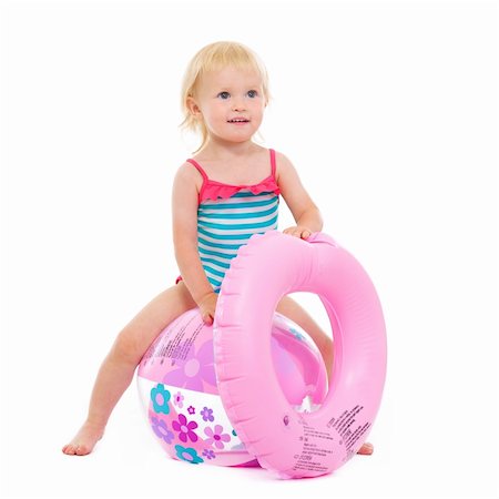 Baby girl in swimsuit with inflatable ring sitting on ball Stock Photo - Budget Royalty-Free & Subscription, Code: 400-06178702