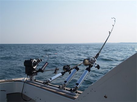 Three fishing poles set up for trolling in lake Michigan on a summer morning with copy space. Photographie de stock - Aubaine LD & Abonnement, Code: 400-06179119