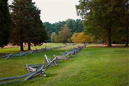 the Surrender Field at Yorktown National Battlefield, Virginia. It was here that the British Army under Cornwallis was defeated by a combined American / French force. Images shows the field at sunset, with rough cut wood fences, tree and a golden glow on the grass of this historic field Foto de stock - Super Valor sin royalties y Suscripción, Código: 400-06179867