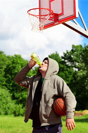 Man holding basketball and drink from bottle of water Foto de stock - Royalty-Free Super Valor e Assinatura, Número: 400-06170956