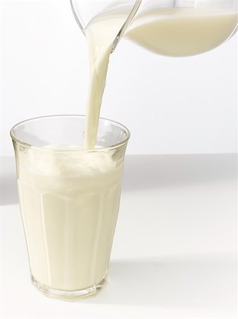 Milk streaming from a glass jug in a glass. Stock Photo - Budget Royalty-Free & Subscription, Code: 400-06173555