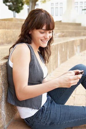 simsearch:400-06204445,k - Teenage Student Sitting Outside On College Steps Using Mobile Phone Foto de stock - Royalty-Free Super Valor e Assinatura, Número: 400-06204177