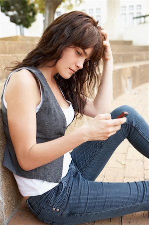 simsearch:400-06204445,k - Unhappy Female Teenage Student Sitting Outside On College Steps Using Mobile Phone Foto de stock - Royalty-Free Super Valor e Assinatura, Número: 400-06204179