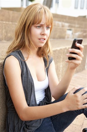 simsearch:400-06204445,k - Unhappy Female Teenage Student Sitting Outside On College Steps Using Mobile Phone Foto de stock - Royalty-Free Super Valor e Assinatura, Número: 400-06204193