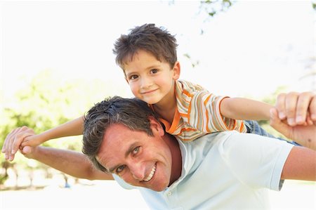 simsearch:400-04042848,k - Father Giving Son Ride On Back In Park Fotografie stock - Microstock e Abbonamento, Codice: 400-06204238