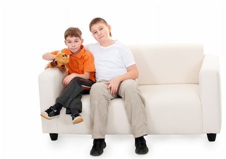Two brothers sitting on a sofa on a white background Stock Photo - Budget Royalty-Free & Subscription, Code: 400-06204471