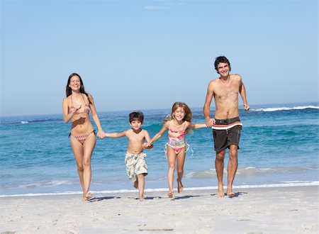 seven year old girls swimsuit - Young Family Running Along Beach on Holiday Stock Photo - Budget Royalty-Free & Subscription, Code: 400-06204516