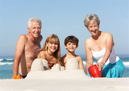 seven year old girls swimsuit - Grandparents And Grandchildren Building Sandcastles Together On Beach Holiday Stock Photo - Budget Royalty-Free & Subscription, Code: 400-06204529