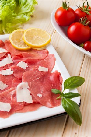 Dish of carpaccio beef with parmesan cheese and lemon Fotografie stock - Microstock e Abbonamento, Codice: 400-06204759