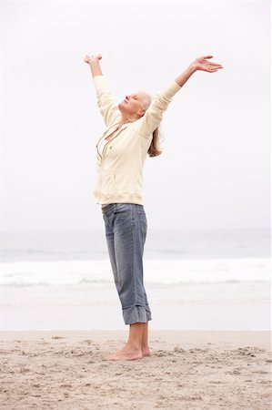 senior women stretching on beach - Senior Woman With Arms Outstretched On Winter Beach Stock Photo - Budget Royalty-Free & Subscription, Code: 400-06204971