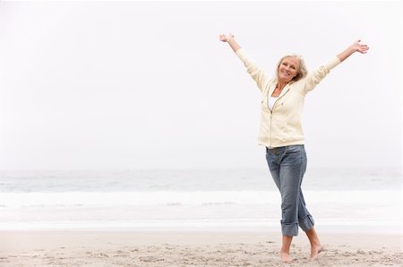 senior women stretching on beach - Senior Woman With Arms Outstretched On Winter Beach Stock Photo - Budget Royalty-Free & Subscription, Code: 400-06204972