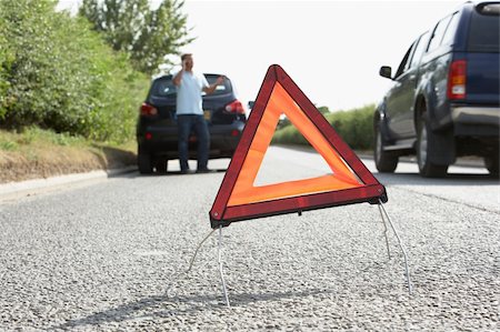 Driver Broken Down On Country Road With Hazard Warning Sign In Foreground Stock Photo - Budget Royalty-Free & Subscription, Code: 400-06205206