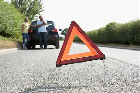 Couple Broken Down On Country Road With Hazard Warning Sign In Foreground Stock Photo - Budget Royalty-Free & Subscription, Code: 400-06205207