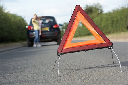 Mother And Daughter Broken Down On Country Road With Hazard Warning Sign In Foreground Stock Photo - Budget Royalty-Free & Subscription, Code: 400-06205216