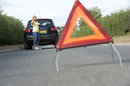 Female Driver Broken Down On Country Road With Hazard Warning Sign In Foreground Stock Photo - Budget Royalty-Free & Subscription, Code: 400-06205217