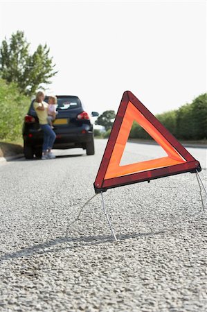 Mother And Daughter Broken Down On Country Road With Hazard Warning Sign In Foreground Stock Photo - Budget Royalty-Free & Subscription, Code: 400-06205211