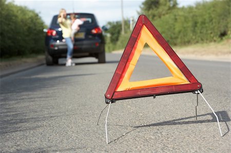 Mother And Daughter Broken Down On Country Road With Hazard Warning Sign In Foreground Stock Photo - Budget Royalty-Free & Subscription, Code: 400-06205212