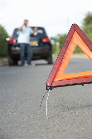 Driver Broken Down On Country Road With Hazard Warning Sign In Foreground Stock Photo - Budget Royalty-Free & Subscription, Code: 400-06205224
