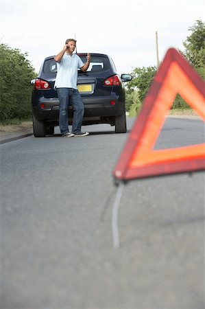 Driver Broken Down On Country Road With Hazard Warning Sign In Foreground Stock Photo - Budget Royalty-Free & Subscription, Code: 400-06205226