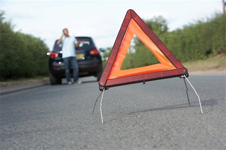 Driver Broken Down On Country Road With Hazard Warning Sign In Foreground Stock Photo - Budget Royalty-Free & Subscription, Code: 400-06205221