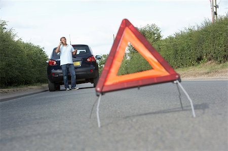 Driver Broken Down On Country Road With Hazard Warning Sign In Foreground Foto de stock - Super Valor sin royalties y Suscripción, Código: 400-06205222