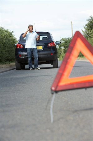 Driver Broken Down On Country Road With Hazard Warning Sign In Foreground Stock Photo - Budget Royalty-Free & Subscription, Code: 400-06205223