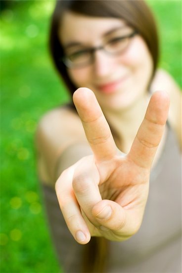 smiling young woman making victory gesture towards the camera Stock Photo - Royalty-Free, Artist: Alan_Smithee, Image code: 400-06207246