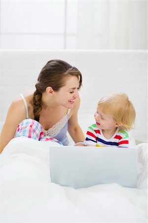Young mother and baby playing with laptop in bed Stock Photo - Budget Royalty-Free & Subscription, Code: 400-06208021