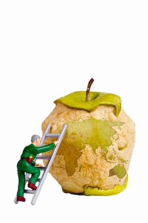 decaying fruit photography - Figurine of a man climbing a ladder on an apple with a silhouette of an earth to fix it. Stock Photo - Budget Royalty-Free & Subscription, Code: 400-06208588