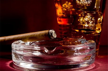 simsearch:400-05292494,k - Close-up selective focus of a burning cigar with a glass of whiskey in the background. Stock Photo - Budget Royalty-Free & Subscription, Code: 400-06208589