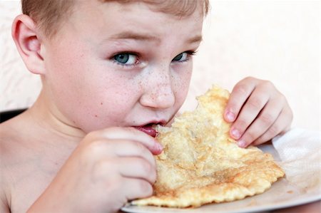 Closeup portrait of little boy eating meat pie named ?cheburek? Foto de stock - Super Valor sin royalties y Suscripción, Código: 400-06201823