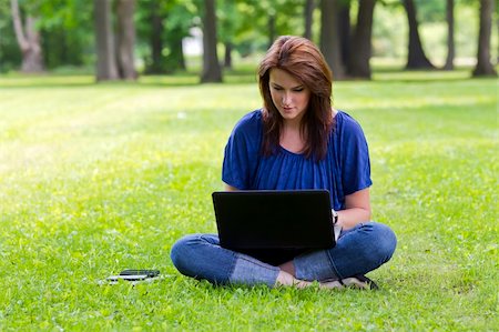 A beautiful brunette model working on a computer and talking on a mobile phone in an outdoor environment Stock Photo - Budget Royalty-Free & Subscription, Code: 400-06202816