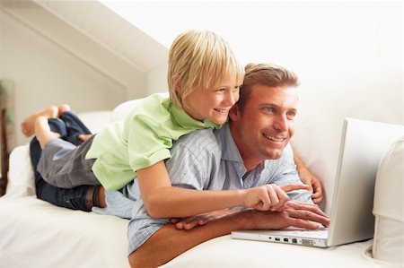 simsearch:400-04044108,k - Father And Son Using Laptop Relaxing Sitting On Sofa At Home Stock Photo - Budget Royalty-Free & Subscription, Code: 400-06203984