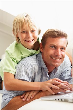 simsearch:400-04044108,k - Father And Son Using Laptop Relaxing Sitting On Sofa At Home Stock Photo - Budget Royalty-Free & Subscription, Code: 400-06203982