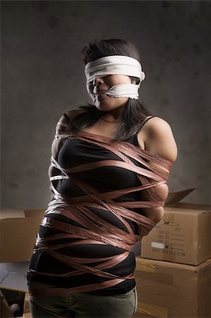 A young woman tied-up, blind folded and muted in old room. Low key setting Stock Photo - Budget Royalty-Free & Subscription, Code: 400-06328871