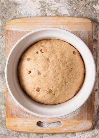 A bread dough with sultanas or raisins rising in a white bowl on top of a flour dusted cutting board. Photographie de stock - Aubaine LD & Abonnement, Code: 400-06328964