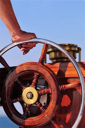 Hand holding a wooden yacht steering wheel Photographie de stock - Aubaine LD & Abonnement, Code: 400-06330198