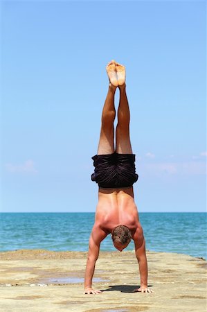 fogen (artist) - Young athlete is engaged in gymnastics at the background of sea and sky. Stockbilder - Microstock & Abonnement, Bildnummer: 400-06330284