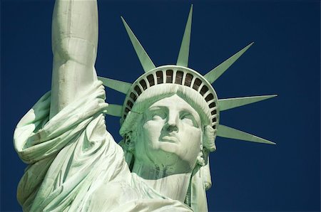 estatua de la libertad - Close-up of the Statue of Liberty face and crown against deep blue sky Foto de stock - Super Valor sin royalties y Suscripción, Código: 400-06330730