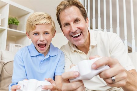 sofa two boys video game - Happy family, man and boy, father, son, having fun playing video console games together. Stock Photo - Budget Royalty-Free & Subscription, Code: 400-06331211