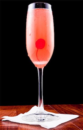 pink champagne cocktail with a cherry isolated on a black background Stock Photo - Budget Royalty-Free & Subscription, Code: 400-06331348