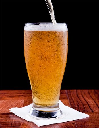 light beer on a bar top isolated on a black background Photographie de stock - Aubaine LD & Abonnement, Code: 400-06331350