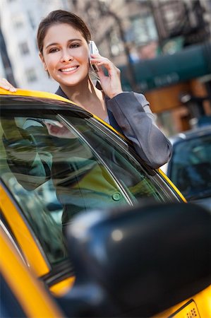 A happy young woman talking on her mobile cell phone by a yellow taxi cab. Shot on location in New York City Stock Photo - Budget Royalty-Free & Subscription, Code: 400-06332106